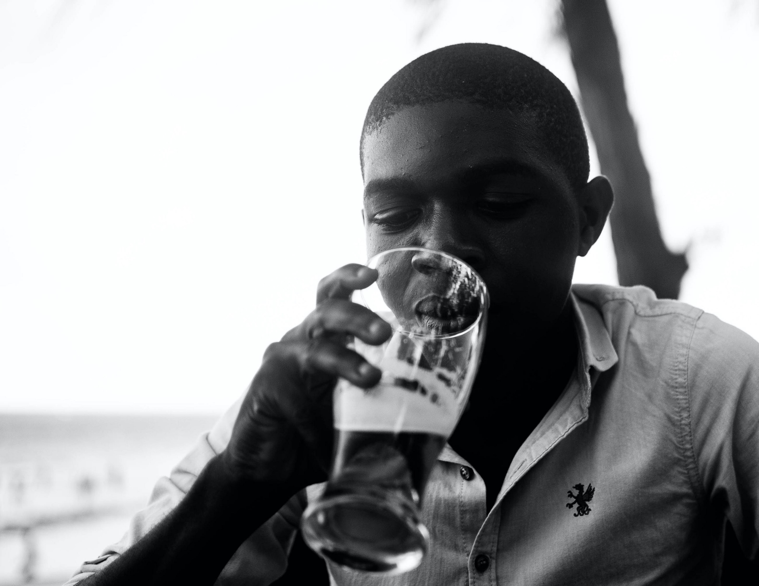 a man looks down into an almost empty glass of beer